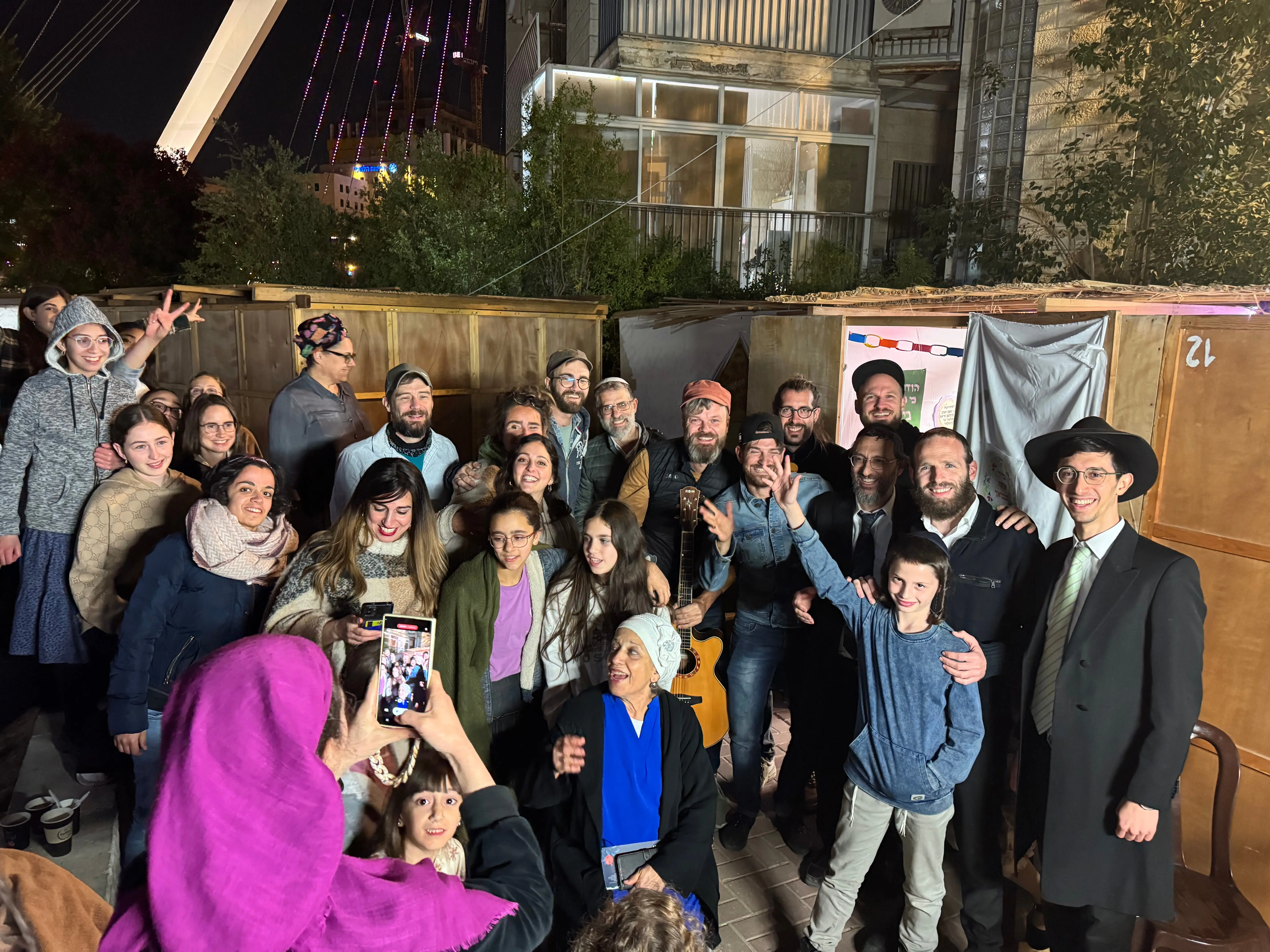 Gruppenbild vor den Laubhütten – unser Team zusammen mit ultraorthodoxen Gastgebern
